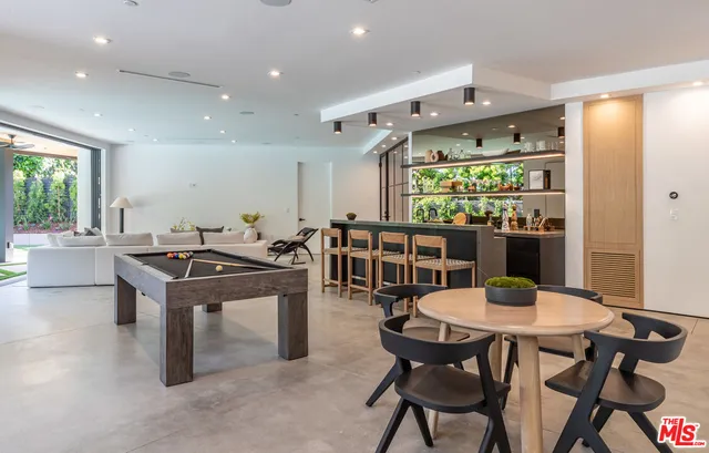 a kitchen with stainless steel appliances kitchen island granite countertop a table and chairs in it