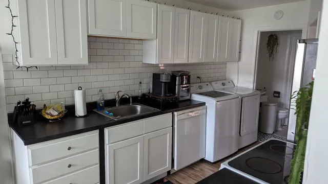 a kitchen with white cabinets and sink