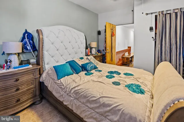 a bed sitting in a bedroom next to a window with dresser