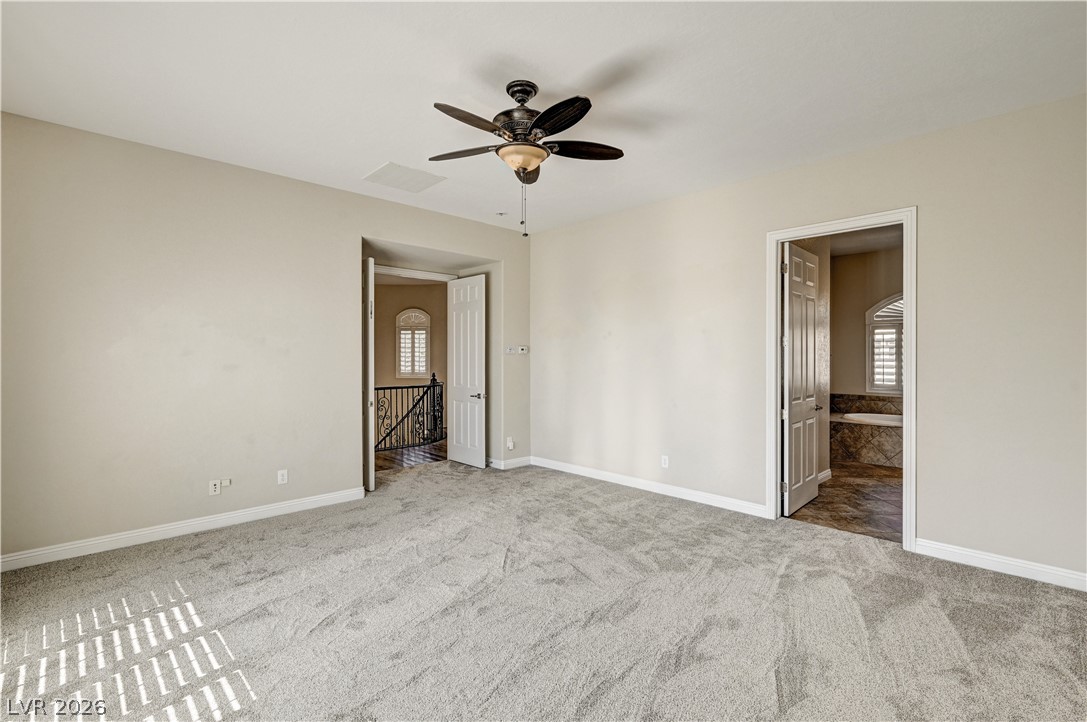 2793 Rosenhearty Drive Henderson, NV 89044 - Photo 39 of 77 A quiet retreat with plush carpeting awaits, connecting seamlessly to a bath and an elegant stairway.