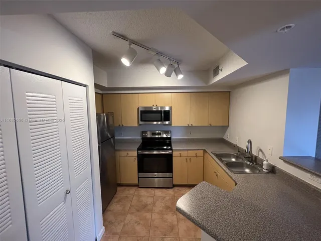 a kitchen with a refrigerator and white cabinets