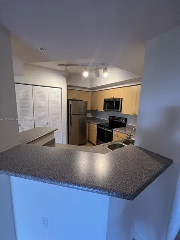 a kitchen with kitchen island a sink dishwasher stove and refrigerator with wooden floor