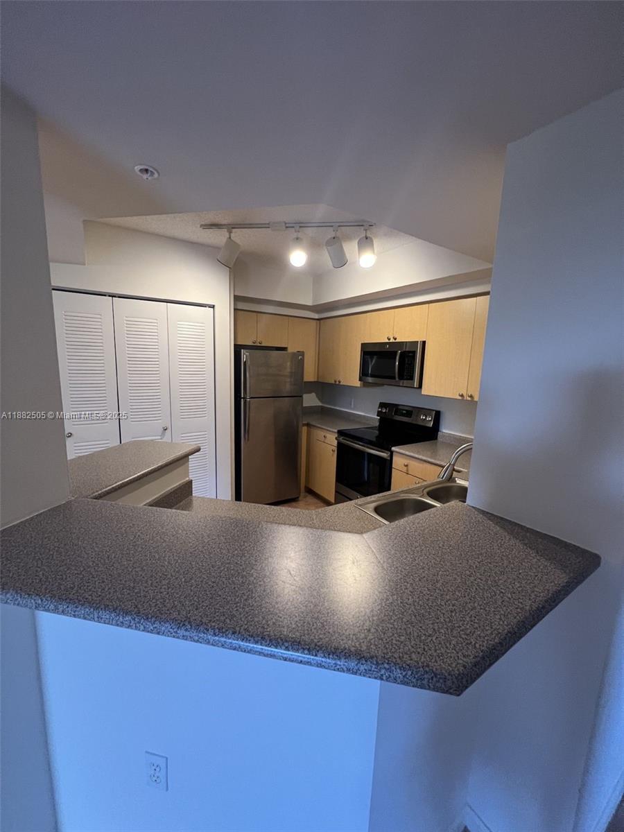 1919 Van Buren Street, Unit 408A Hollywood, FL 33020 - Photo 4 of 19 a kitchen with kitchen island a sink dishwasher stove and refrigerator with wooden floor