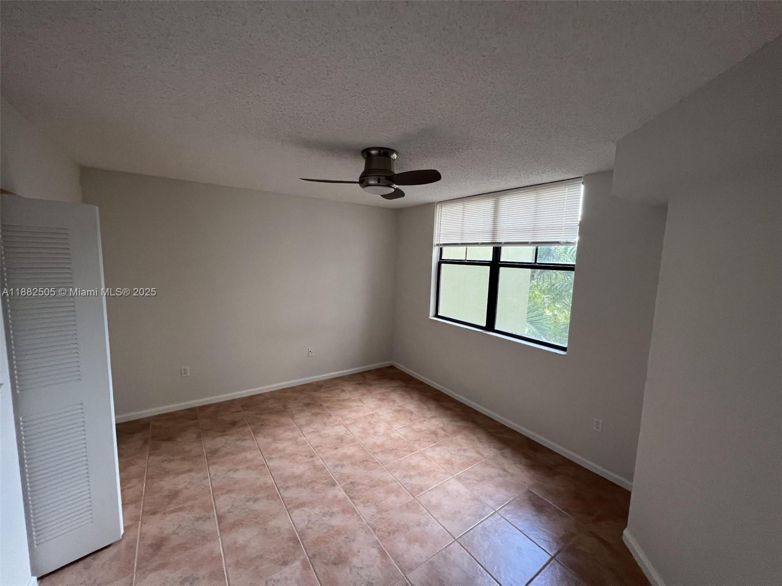 1919 Van Buren Street, Unit 408A Hollywood, FL 33020 - Photo 8 of 19 an empty room with windows and ceiling fan