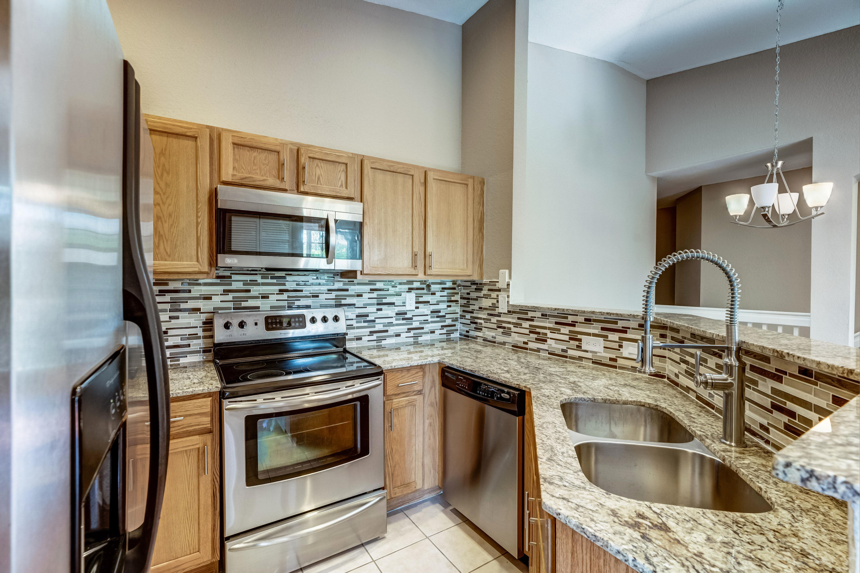 3174 Laurel Ridge Circle Riviera Beach, FL 33404 - Photo 1 of 32 a kitchen with a sink stove and microwave