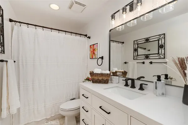 a bathroom with a sink a toilet and a large mirror