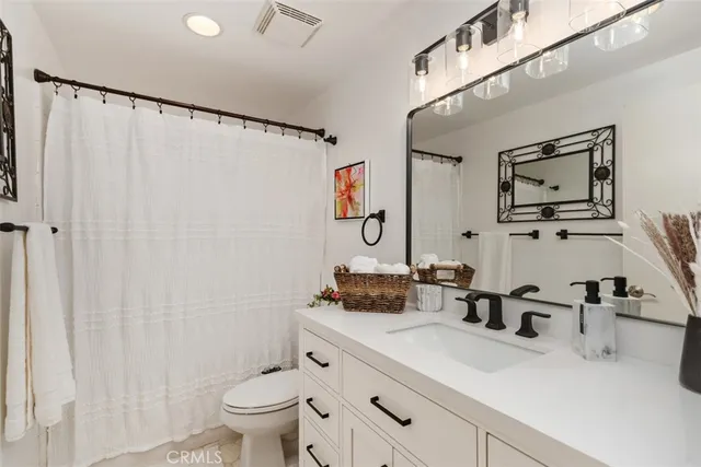 a bathroom with a sink a toilet and a large mirror
