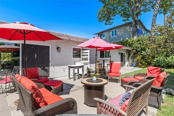 a view of a patio with a dining table and chairs under an umbrella