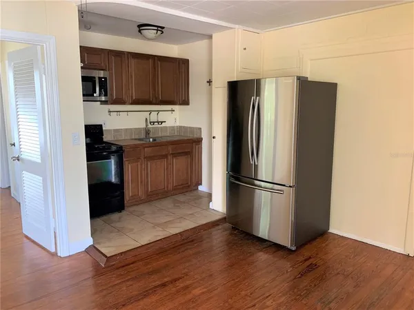 a kitchen with granite countertop white cabinets and stainless steel appliances