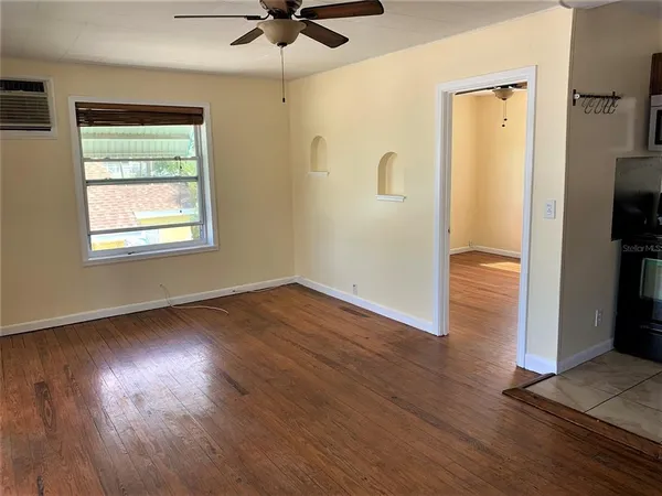 a kitchen with stainless steel appliances wooden floor and window