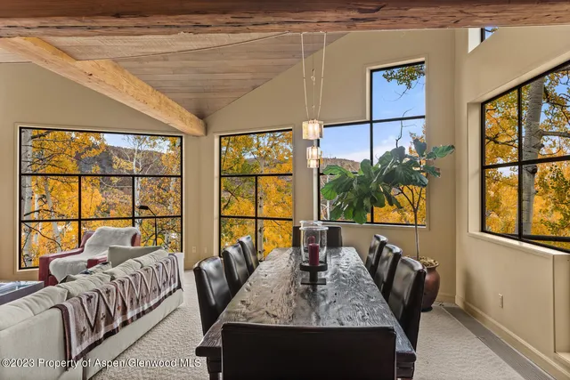 a living room with furniture and floor to ceiling windows