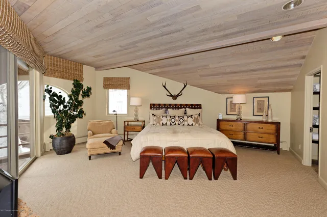 a bedroom with a bed next to a window