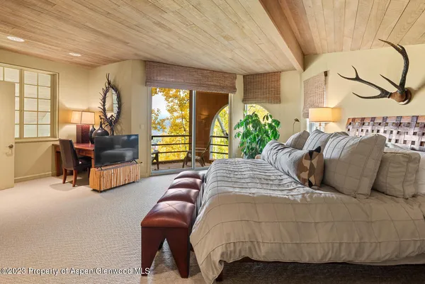 a bedroom with a large bed couch and a window