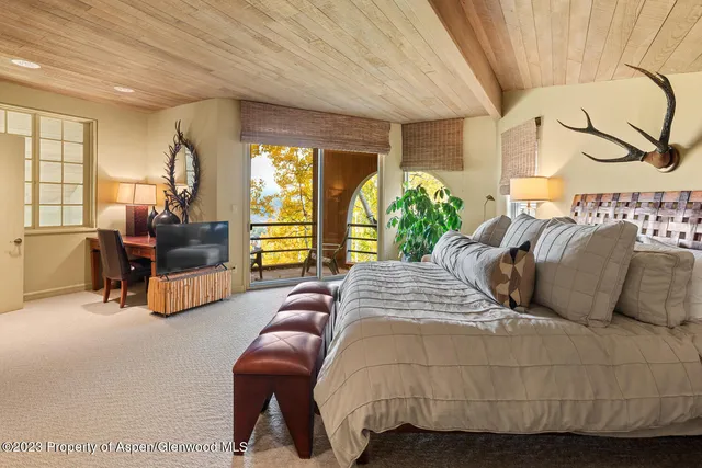a bedroom with a large bed couch and a window