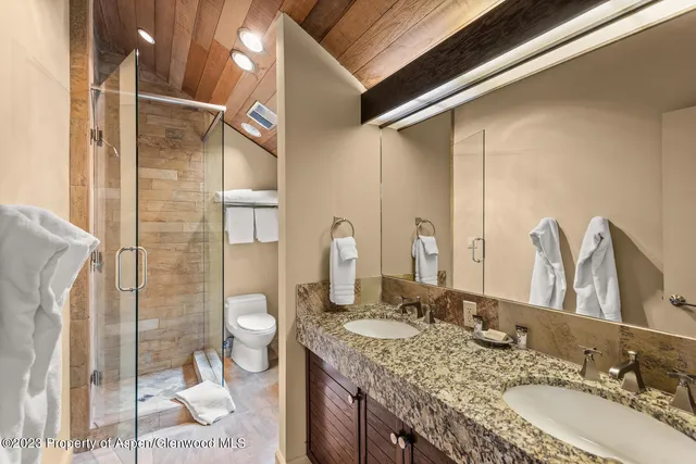 a en suite bathroom with a granite countertop sink and a mirror