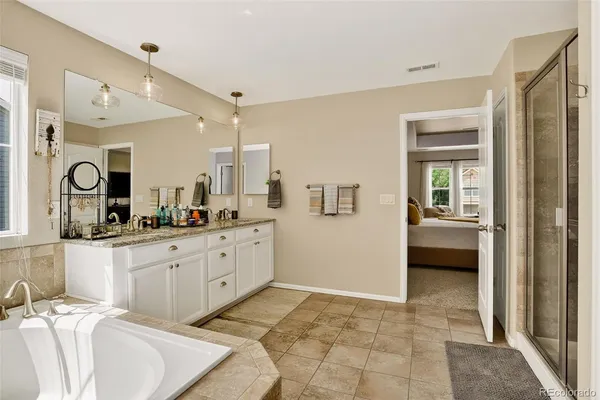 a spacious bathroom with a mirror and a sink