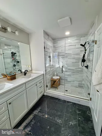 a bathroom with a double vanity sink mirror and shower