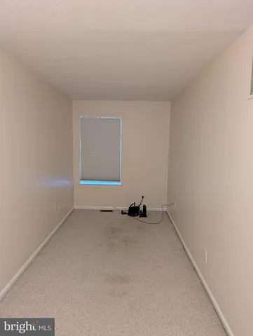 an empty room with a ceiling fan and a window