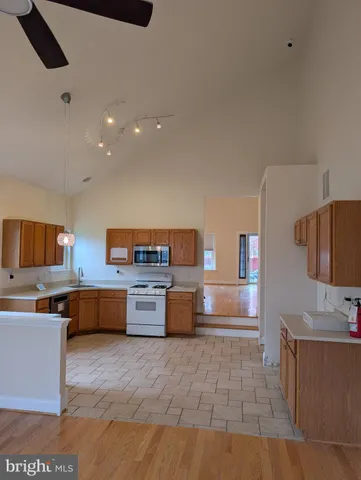a kitchen with stainless steel appliances wooden cabinets a stove top oven a sink and dishwasher