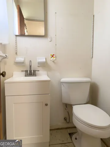 a bathroom with a toilet a sink and mirror