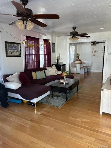 a living room with furniture a ceiling fan and a rug
