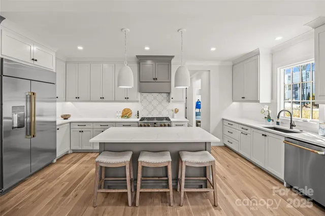 a kitchen that has a lot of cabinets in it and wooden floors