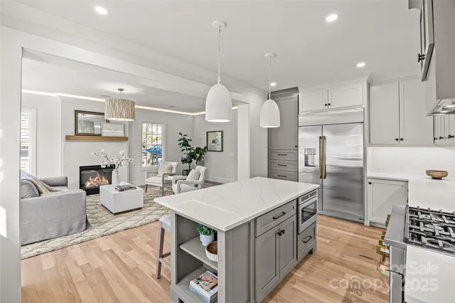 a kitchen with stainless steel appliances a stove a sink cabinets and a refrigerator