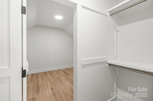 a view of a room with wooden floor and a small space