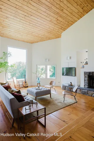 a living room with furniture a fireplace and wooden floor