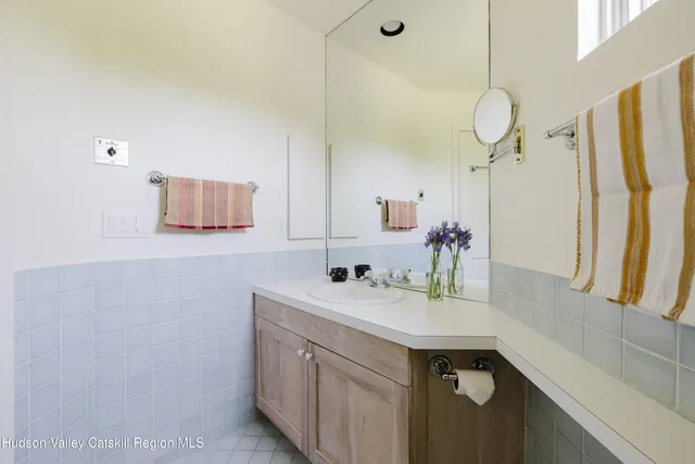 a view of a lake with lawn chairs and large trees