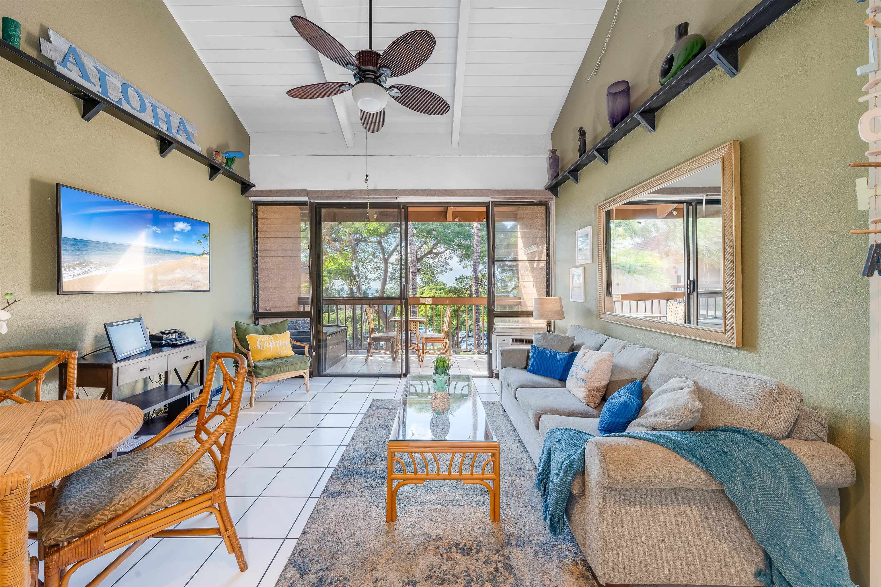 2191 South Kihei Road, Unit 2413 Kihei, HI 96753 - Photo 10 of 34 a living room with furniture a flat screen tv and a large window