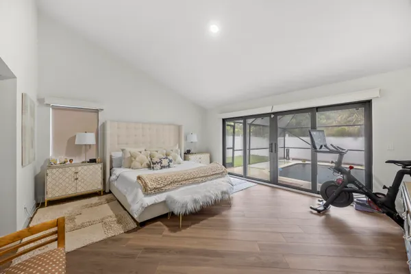 a bedroom with a bed and large windows
