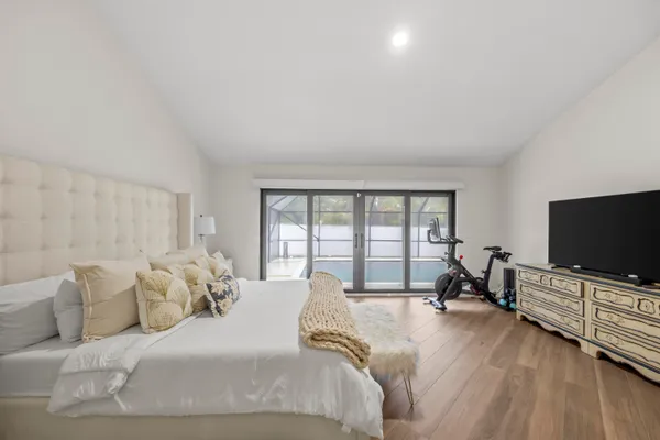 a spacious bedroom with a bed and a flat screen tv