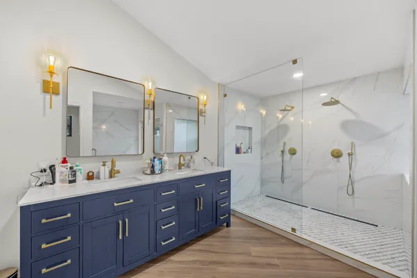 a bathroom with a double vanity sink mirror double and shower