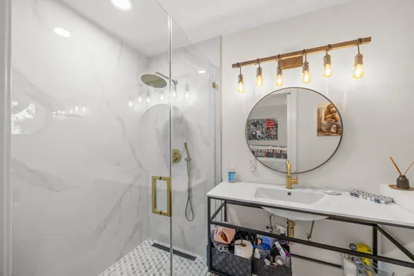 a bathroom with a sink a mirror and shower
