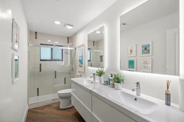 a bathroom with a double vanity sink toilet and shower