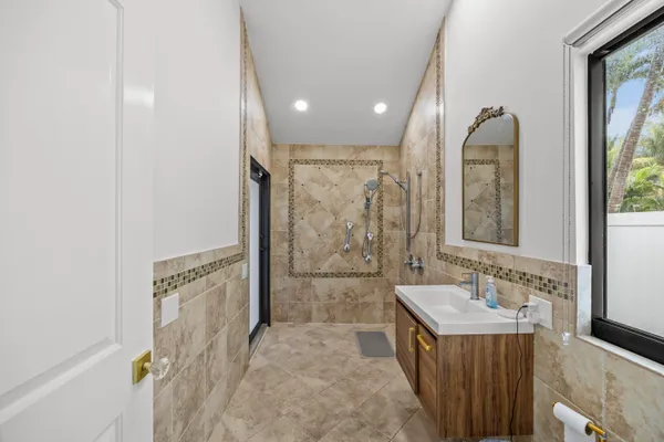 a bathroom with a granite countertop sink a mirror and shower