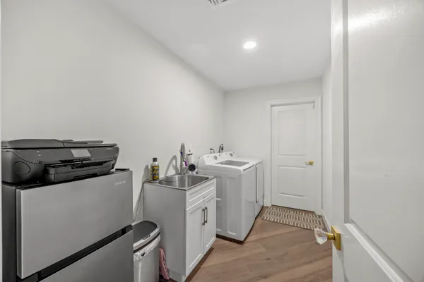 a utility room with sink dryer and washer