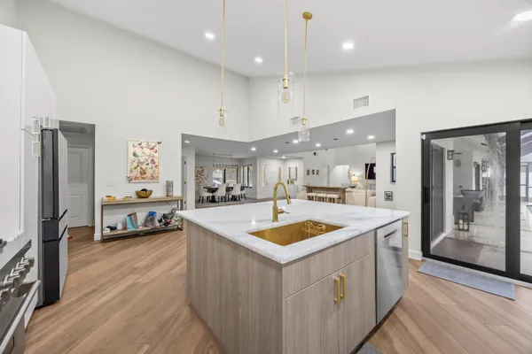a kitchen with stainless steel appliances granite countertop a sink and a refrigerator