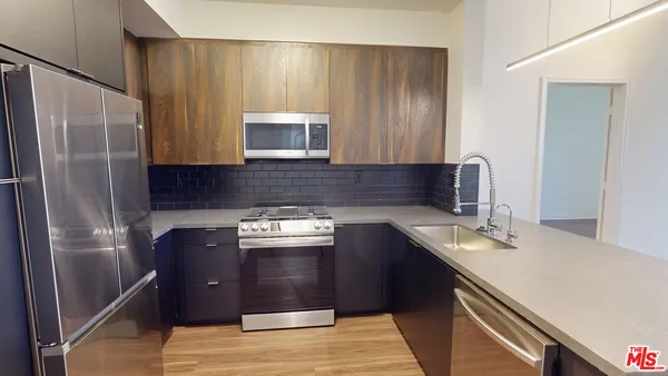 a kitchen with stainless steel appliances granite countertop a refrigerator stove and sink