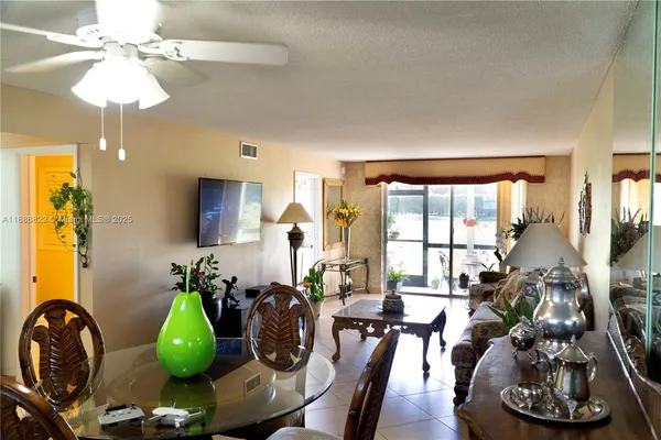 a living room with furniture a chandelier and a large window