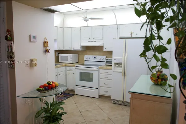 a kitchen with white cabinets and white appliances