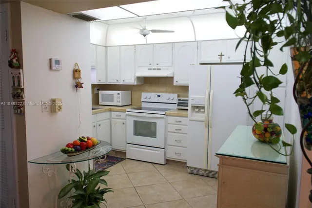 a kitchen with white cabinets and white appliances