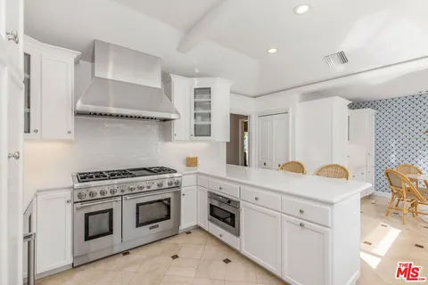 a kitchen with stainless steel appliances granite countertop a stove and a sink