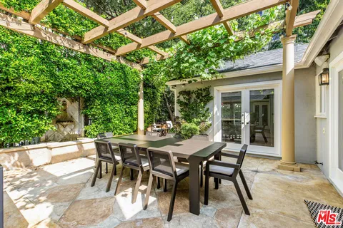 a view of a patio with a table and chairs and potted plants