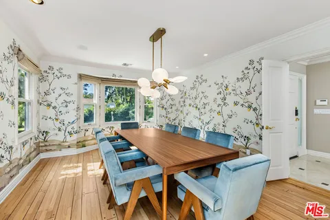 a living room with a table chairs and a chandelier