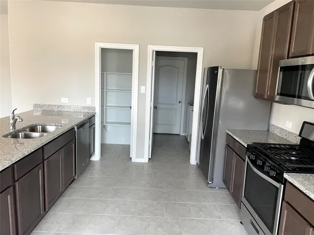 a kitchen with stainless steel appliances granite countertop a refrigerator and a stove top oven