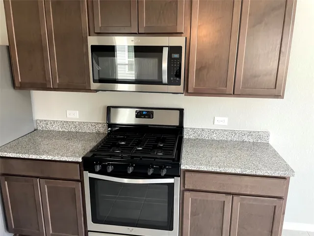 a kitchen with granite countertop stainless steel appliances and cabinets