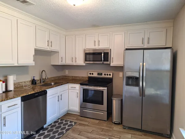 a kitchen with a refrigerator stove and microwave