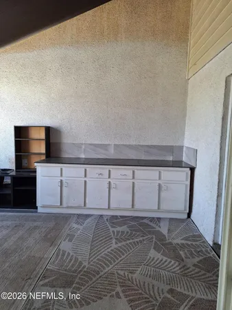 a view of a small space with wooden floor and a window
